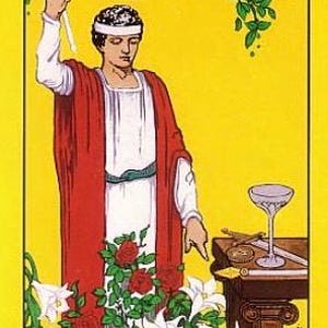 Puede incluir: La carta del tarot El Mago presenta a un hombre con una t&uacute;nica roja sosteniendo una varita, con un s&iacute;mbolo de infinito sobre su cabeza. La carta est&aacute; sobre un fondo amarillo con un rosal y lirios blancos en primer plano. El n&uacute;mero de la carta, "1", y el nombre de la carta, "EL MAGO", est&aacute;n impresos en la parte inferior.
