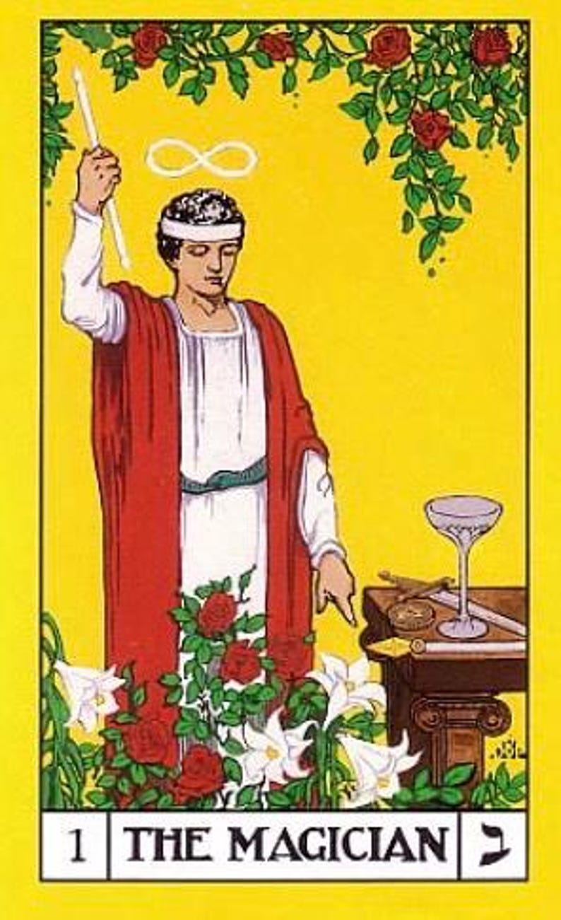 Puede incluir: La carta del tarot El Mago presenta a un hombre con una t&uacute;nica roja sosteniendo una varita, con un s&iacute;mbolo de infinito sobre su cabeza. La carta est&aacute; sobre un fondo amarillo con un rosal y lirios blancos en primer plano. El n&uacute;mero de la carta, "1", y el nombre de la carta, "EL MAGO", est&aacute;n impresos en la parte inferior.