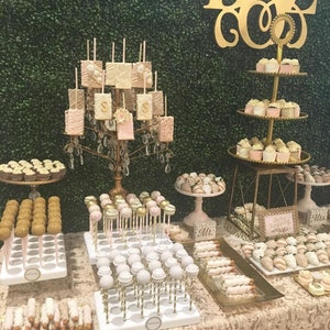 Könnte beinhalten: Ein Hochzeitstortenbuffet mit einer Auswahl an Leckereien, darunter Cake Pops, Schokoladen-Erdbeeren und Cupcakes. Der Tisch ist mit goldenen Akzenten und einem grünen Hintergrund dekoriert. Das Schild auf dem Tisch lautet "Unsere Hochzeit für immer".