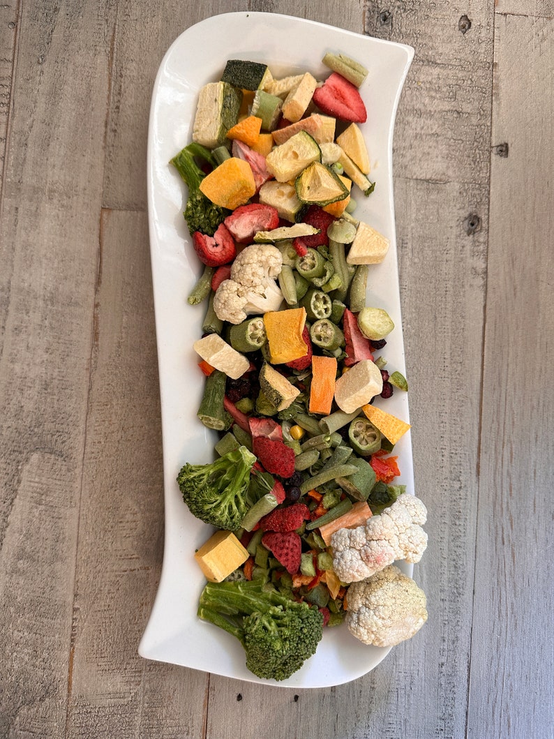 May include: A white platter filled with a variety of dried fruits and vegetables, including strawberries, broccoli, cauliflower, and green beans.

“Premium freeze-dried bird food by Runzas made with real fruits and vegetables for parrots”