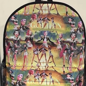 Może przedstawiać: Kolorowy plecak z powtarzającym się wzorem stylizowanych postaci w strojach scenicznych. Słowo "GOLDEN" jest widoczne z przodu. Plecak ma czarny uchwyt i boczną kieszeń z siatki.