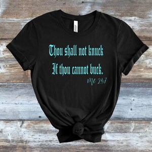 May include: Black t-shirt with a turquoise blue graphic that reads "Thou shall not knock if thou cannot buck. Mc 24:7"