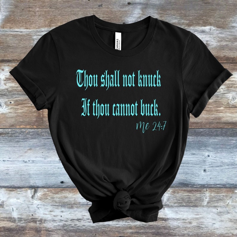 May include: Black t-shirt with a turquoise blue graphic that reads "Thou shall not knock if thou cannot buck. Mc 24:7"