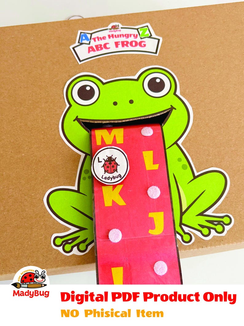K&ouml;nnte beinhalten: Eine Papp-Aktivit&auml;t mit einem gr&uuml;nen Frosch mit weitem Maul und einer langen roten Zunge. Auf der Zunge befinden sich die gelben Buchstaben M, L, K, J, I und ein runder Marienk&auml;fer-Chip. Dar&uuml;ber steht The Hungry ABC FROG.