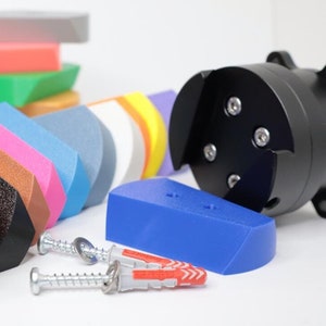 Può includere: Assortimento di blocchi di plastica colorati di diverse forme e dimensioni, tra cui un blocco nero con una superficie testurizzata. Sono inclusi anche due viti argentate e un tassello di plastica rosso.