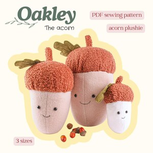 May include: Three plush acorn toys in different sizes with textured rust-coloured caps and light-coloured bodies. Each has a small green leaf, embroidered eyes, and a smile. Text reads: Oakley The acorn, PDF sewing pattern, acorn plushie, 3 sizes.