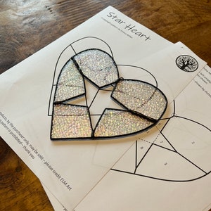 May include: A stained glass pattern for a heart-shaped project called "Star Heart". The pattern is printed on white paper and includes a diagram with numbered sections.