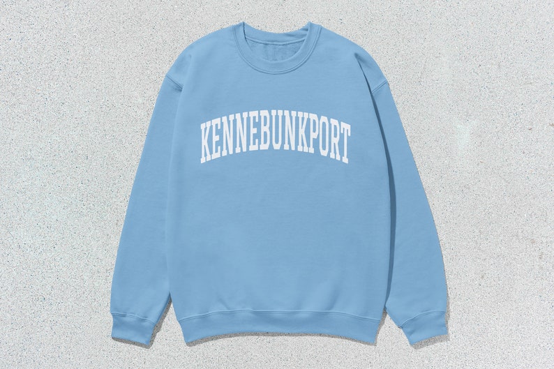 May include: A light blue sweatshirt with the text "KENNEBUNKPORT" printed in white.
