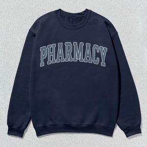 May include: A navy blue sweatshirt with the word "PHARMACY" printed in white on the front.