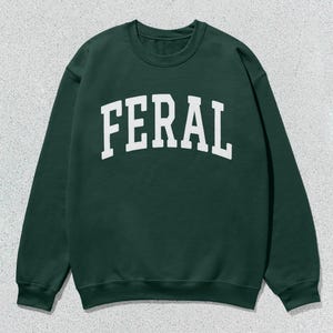 May include: A dark green sweatshirt with the word "FERAL" printed in white on the front.