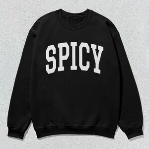 Może przedstawiać: Czarna bluza z białym napisem "SPICY" w stylu uniwersyteckim.