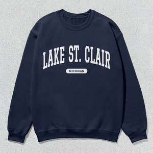 May include: Navy blue sweatshirt with white text that reads "LAKE ST. CLAIR MICHIGAN".
