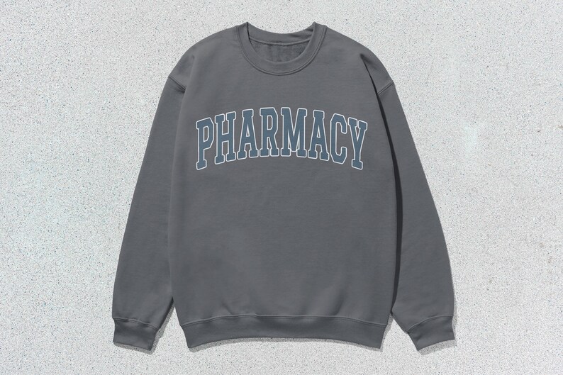 May include: A gray sweatshirt with the word "PHARMACY" printed in a blue and white arch across the front.