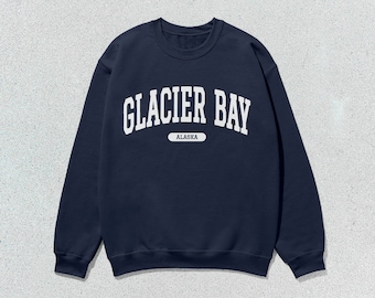 May include: A navy blue sweatshirt with white text that reads "GLACIER BAY ALASKA".