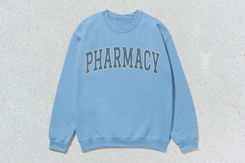 May include: A light blue sweatshirt with the word "PHARMACY" printed in dark gray across the front.
