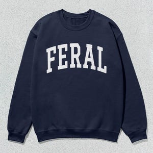 May include: A navy blue sweatshirt with the word "FERAL" printed in white on the front.