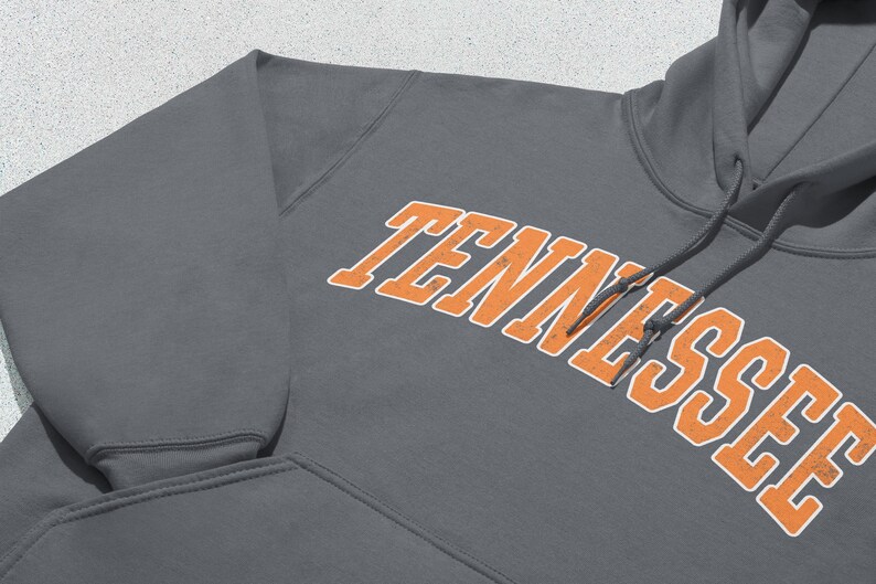 May include: A charcoal gray hooded sweatshirt with the word "TENNESSEE" in orange lettering with white outlines.