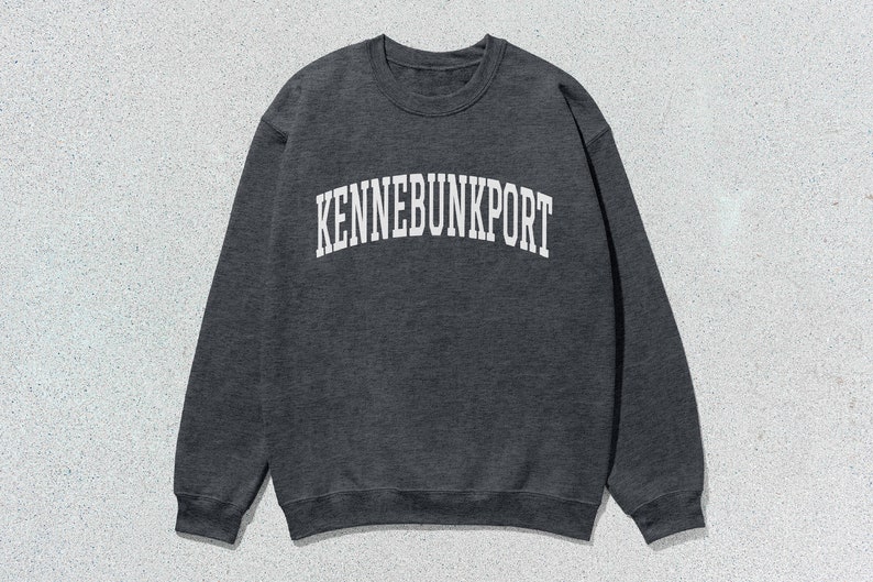 May include: A dark gray sweatshirt with the text "KENNEBUNKPORT" printed in white on the front.