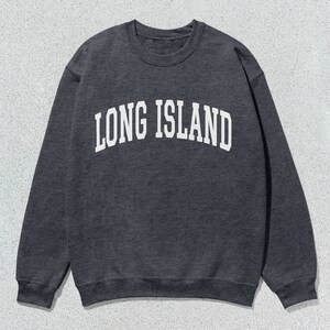 Pu&ograve; includere: Felpa grigio scuro con la scritta "LONG ISLAND" in bianco, a lettere arcuate. La felpa girocollo &egrave; in stile casual, perfetta per l'uso quotidiano. L'immagine &egrave; su uno sfondo neutro.