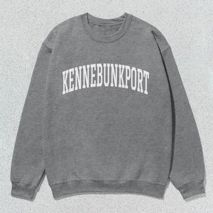 May include: Gray sweatshirt with the text "KENNEBUNKPORT" in white.