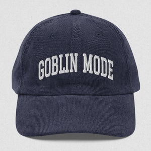 May include: A navy blue corduroy baseball cap with white embroidered text that reads "GOBLIN MODE".