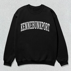 May include: Black sweatshirt with a white arch design that reads "KENNEBUNKPORT".