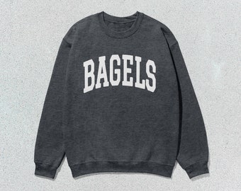 May include: A dark gray sweatshirt with the word "BAGELS" printed in white on the front.