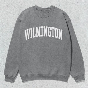 May include: A grey sweatshirt with the word "WILMINGTON" printed in white on the front.