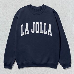 May include: A navy blue sweatshirt with white text that reads "LA JOLLA" in an arched font.
