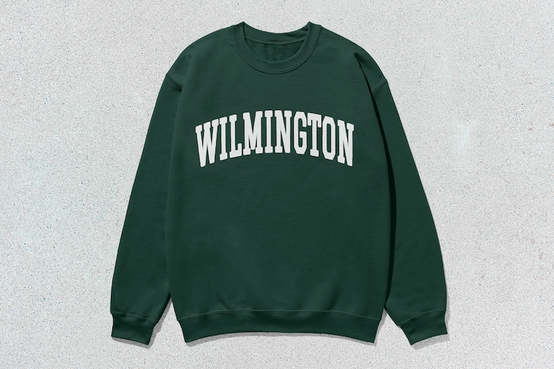 May include: A dark green sweatshirt with the word "WILMINGTON" printed in white on the front.
