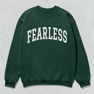 May include: A dark green sweatshirt with the word "FEARLESS" printed in white on the front.