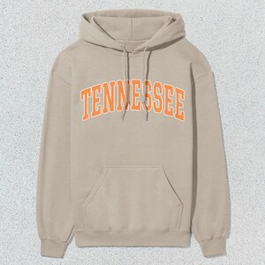 May include: A beige hoodie with an orange "TENNESSEE" graphic on the front.
