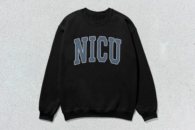 Puede incluir: Sudadera negra de cuello redondo con la palabra "NICU" en letras grandes y en bloque en el pecho. Las letras son de un azul apagado con un contorno blanco. La sudadera tiene mangas largas y un dise&ntilde;o cl&aacute;sico e informal.