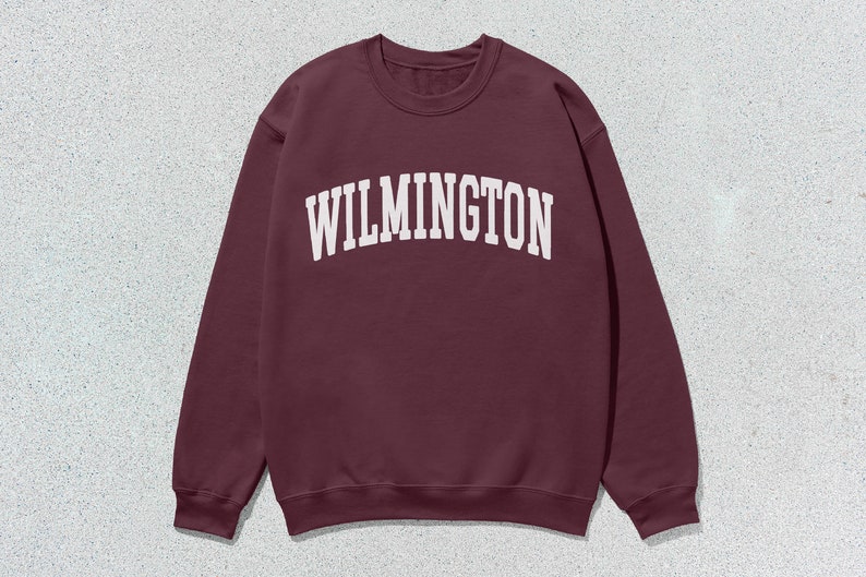 May include: A maroon sweatshirt with the word "WILMINGTON" printed in white on the front.