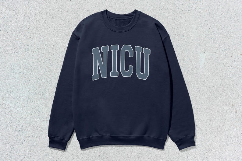Puede incluir: Sudadera azul marino con cuello redondo y la palabra "NICU" en una fuente de estilo universitario en el pecho. Las letras son grises con un contorno blanco. La sudadera tiene mangas largas y un cuello acanalado.