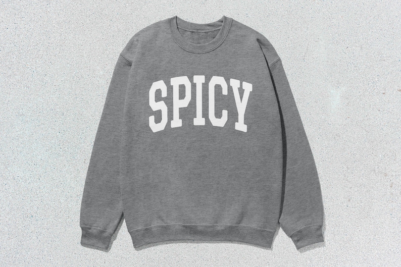 Może przedstawiać: Szara bluza z nadrukiem "SPICY" w kolorze białym na przodzie.