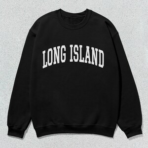 Pu&ograve; includere: Felpa nera girocollo con la scritta bianca "LONG ISLAND" a forma di arco. La felpa &egrave; di colore nero pieno e ha maniche lunghe. Lo sfondo &egrave; grigio maculato.