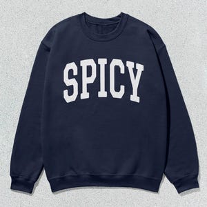 Może przedstawiać: Szarfa w kolorze granatowym z nadrukiem "SPICY" w kolorze białym z przodu.