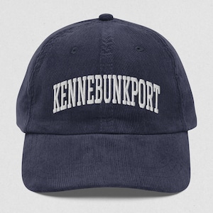 May include: A navy blue corduroy baseball cap with white embroidered text that reads "KENNEBUNKPORT".