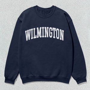 May include: A navy blue sweatshirt with the word "WILMINGTON" printed in white on the front.