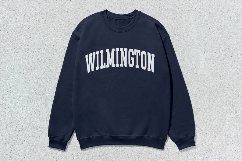 May include: A navy blue sweatshirt with the word "WILMINGTON" printed in white on the front.