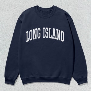 Pu&ograve; includere: Felpa blu navy con la scritta bianca "LONG ISLAND" a forma di arco. La parte superiore a maniche lunghe e girocollo &egrave; realizzata in materiale morbido, adatta per un abbigliamento casual.