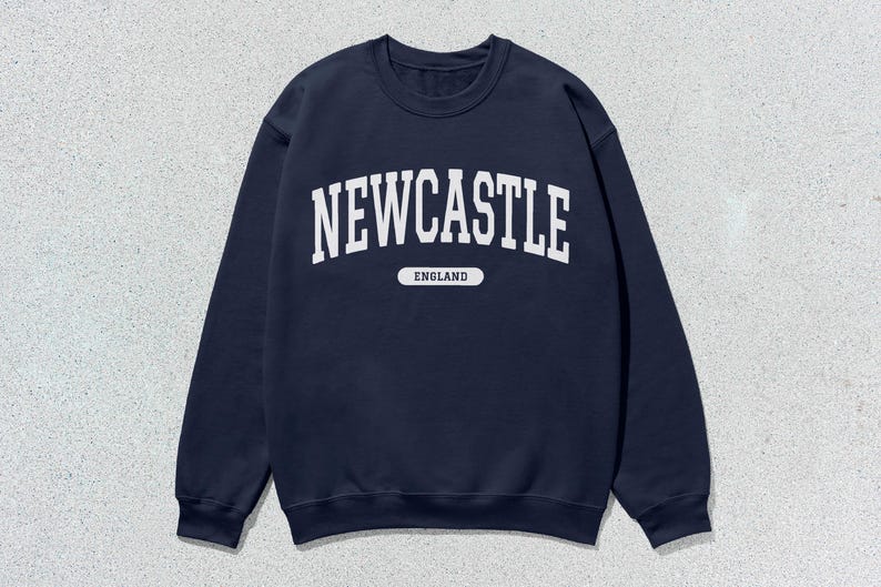 K&ouml;nnte beinhalten: Ein marineblauer Sweatshirt mit dem Aufdruck "NEWCASTLE ENGLAND" in Wei&szlig; auf der Vorderseite.