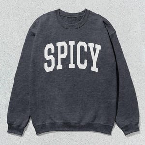 Może przedstawiać: Szara bluza z nadrukiem "SPICY" w kolorze białym na przodzie.