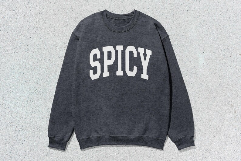 Może przedstawiać: Szara bluza z nadrukiem "SPICY" w kolorze białym na przodzie.