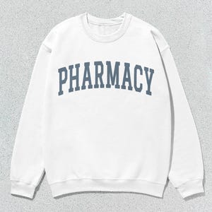 May include: White sweatshirt with a blue arch design that says "PHARMACY" on the front.