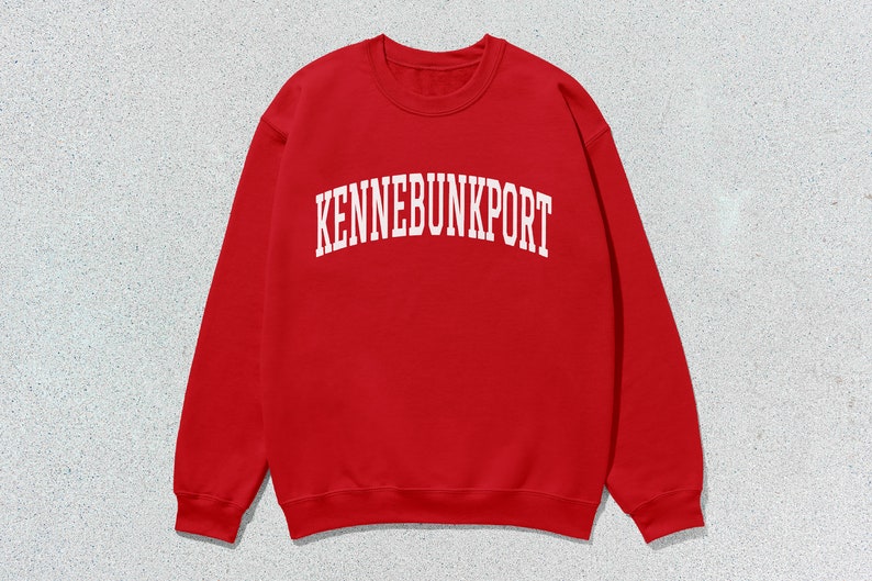 May include: Red sweatshirt with white text that reads "KENNEBUNKPORT" in an arched font.