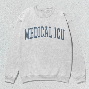 Może przedstawiać: Szara bluza z napisem "MEDICAL ICU" w niebieskich literach.