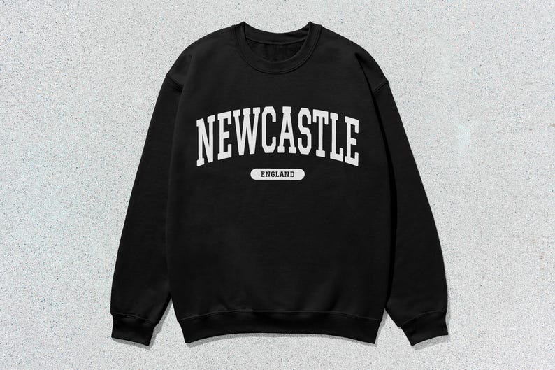 K&ouml;nnte beinhalten: Schwarzer Pullover mit wei&szlig;em Text, der "NEWCASTLE ENGLAND" in einer College-Schriftart lautet.