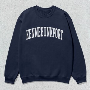 May include: A navy blue sweatshirt with the text "KENNEBUNKPORT" printed in white on the front.